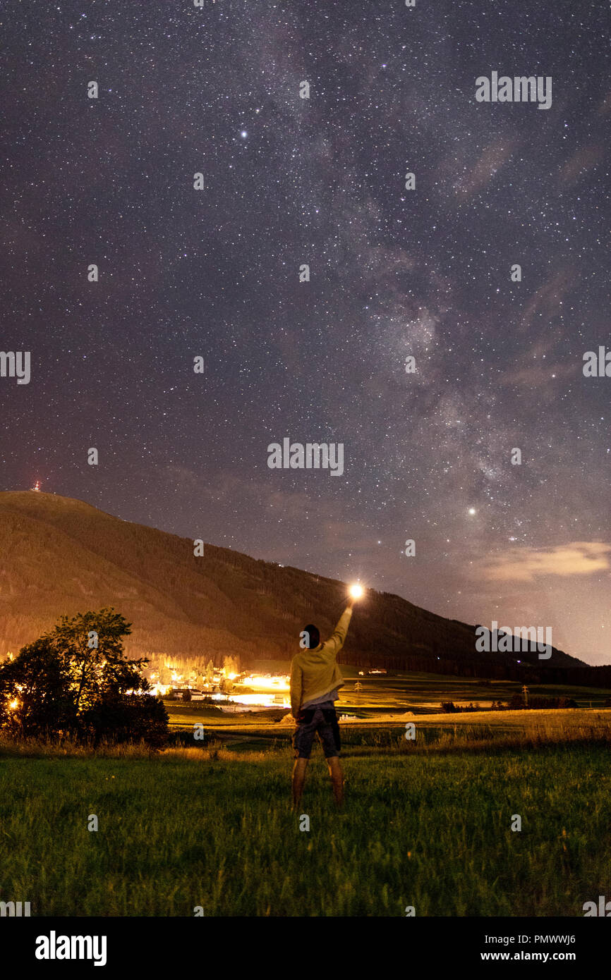 A picture off the Milkyway with a little Village called Sistrans in the back. In the Front, i stood simply with my Mobilephone fot light. Stock Photo