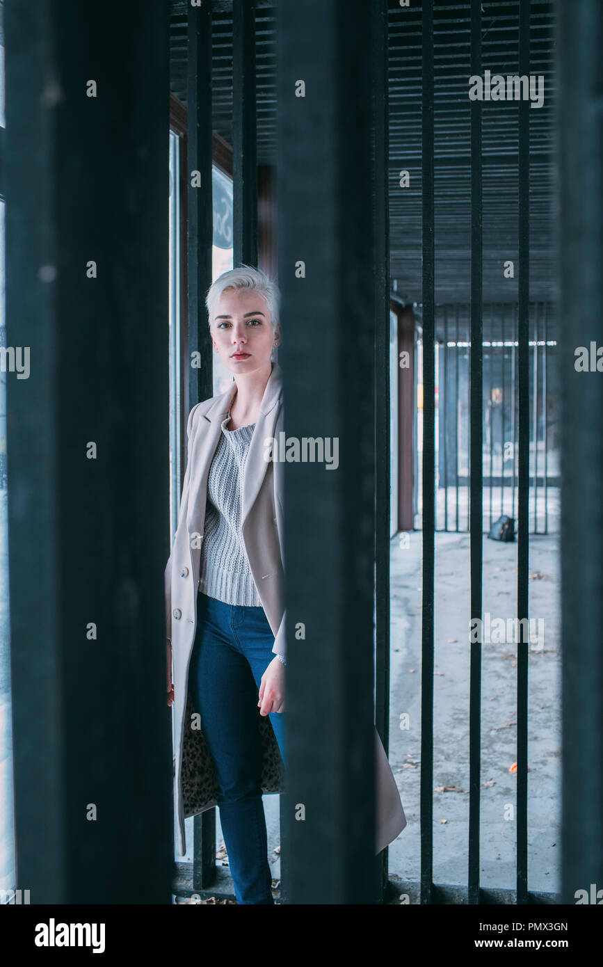 Portrait confident young woman behind gate Stock Photo