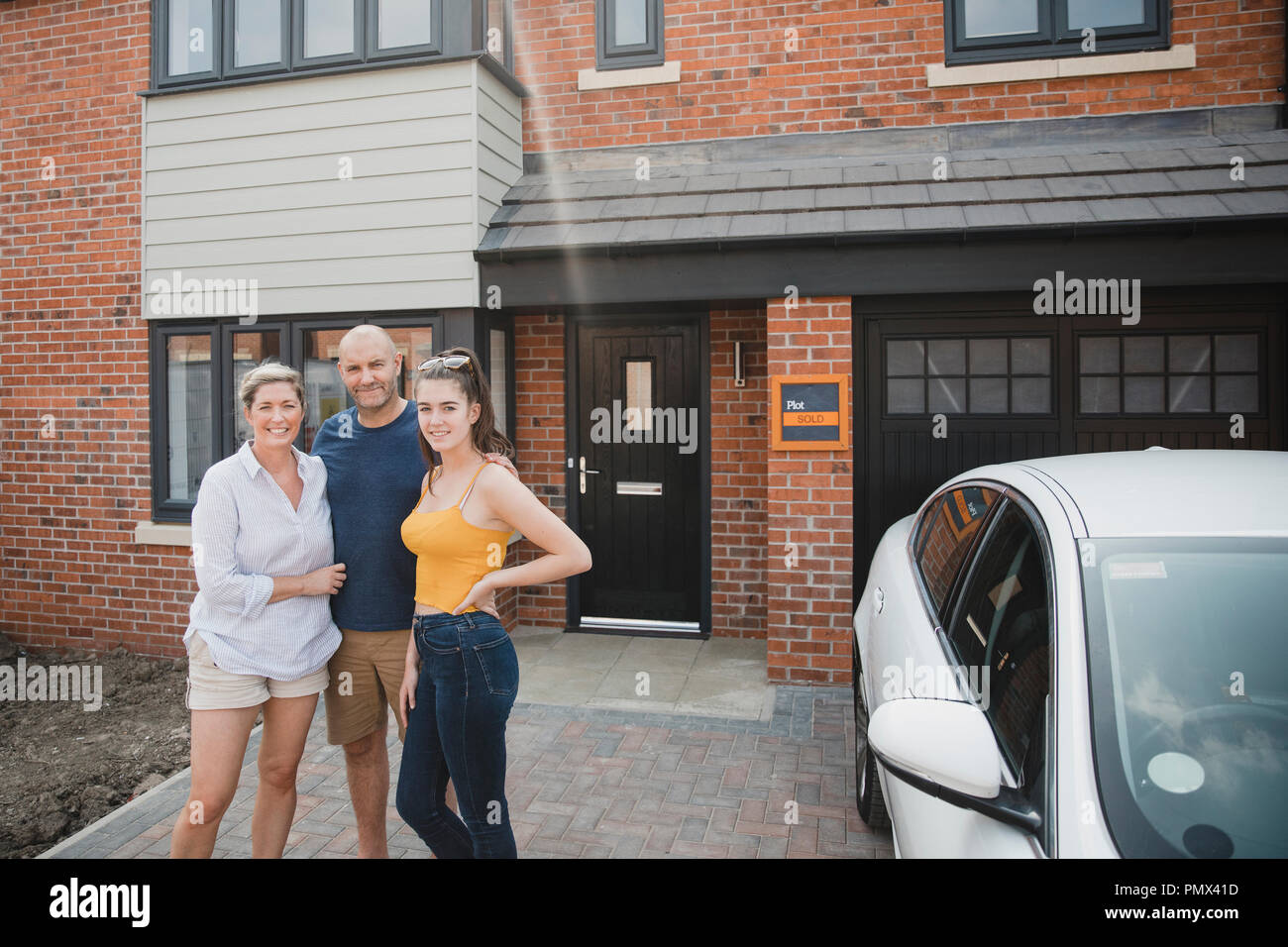 Portrait of a family with one child outside of their new home. Stock Photo
