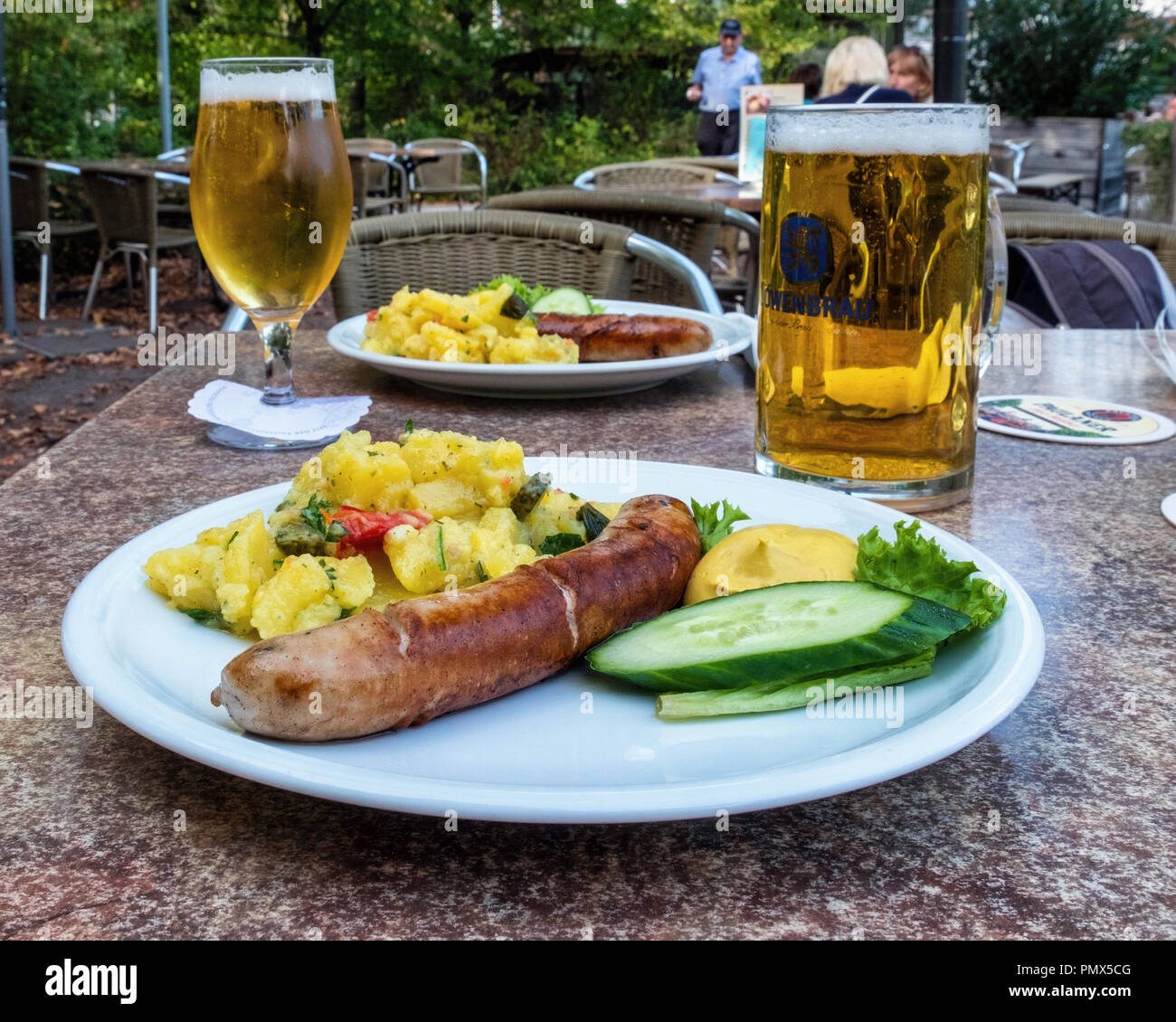 Berlin, Neukölln, Britzer Garden. Sausage, potato salad & mustard meal & beers in glasses on outdoor table of snack bar providing teas & lunches Stock Photo