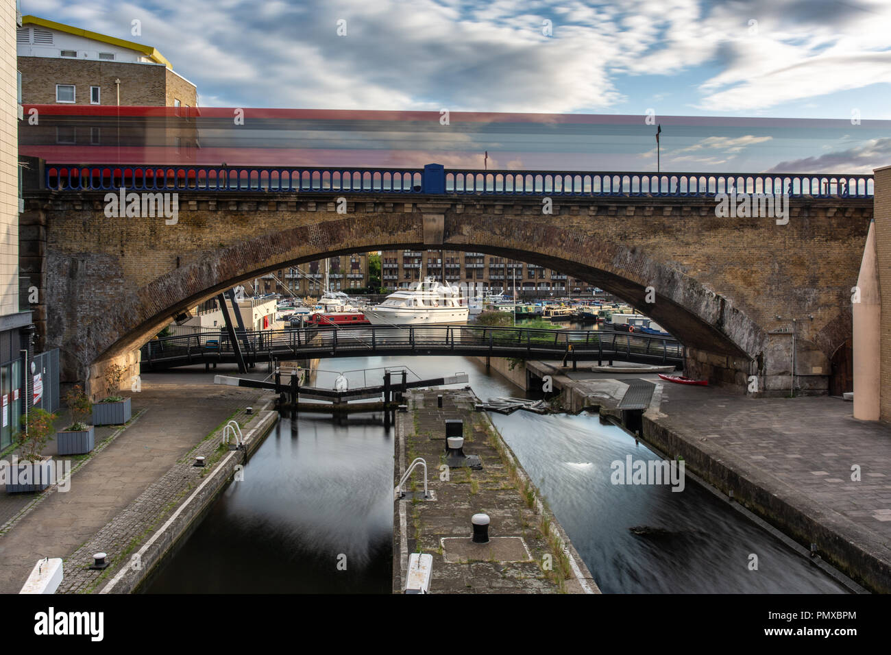 London, England, UK - September 14, 2018: A Docklands Light Railway train forms a blur as it speeds across a viaduct over the Regent's Canal at Limeho Stock Photo