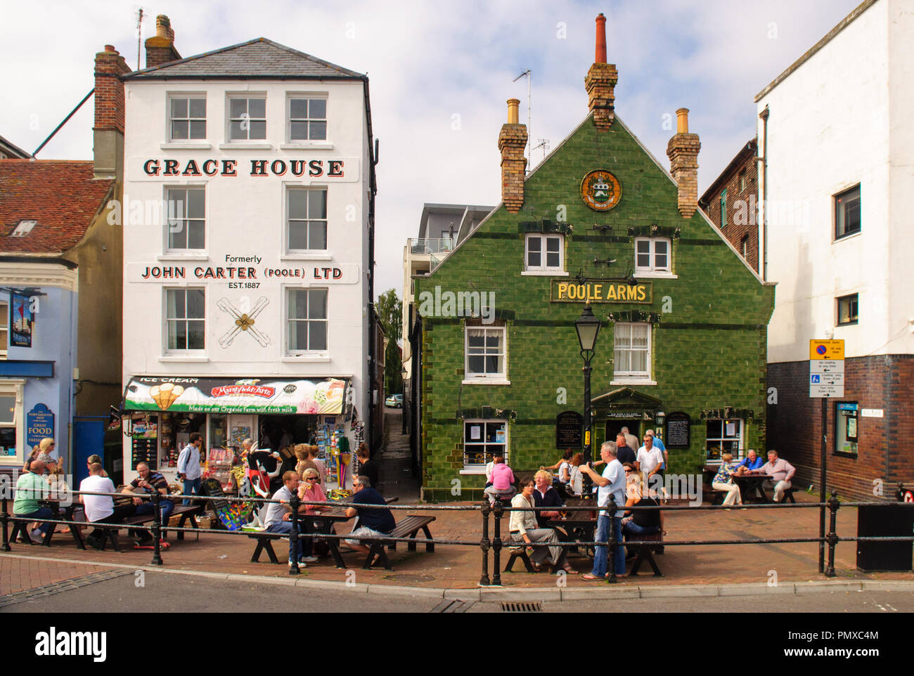 Poole, England, UK - July 30, 2011: Punters drink at picnic benches outside the Poole Arms pub on the Quay in Poole, Dorset. Stock Photo
