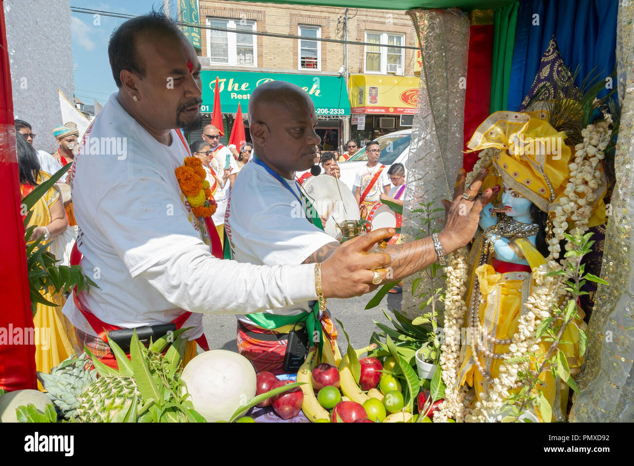Hindu men dressing and adorning a statue of a deity at the 2018