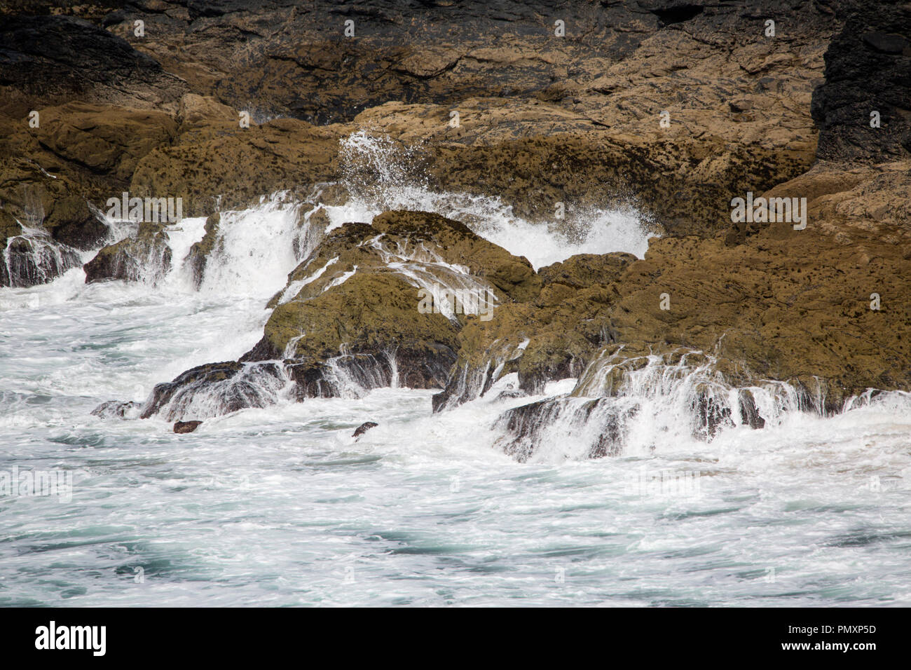 Waves crashing into the cliffs at Church Cove Gunwalloe Cornwall Stock Photo