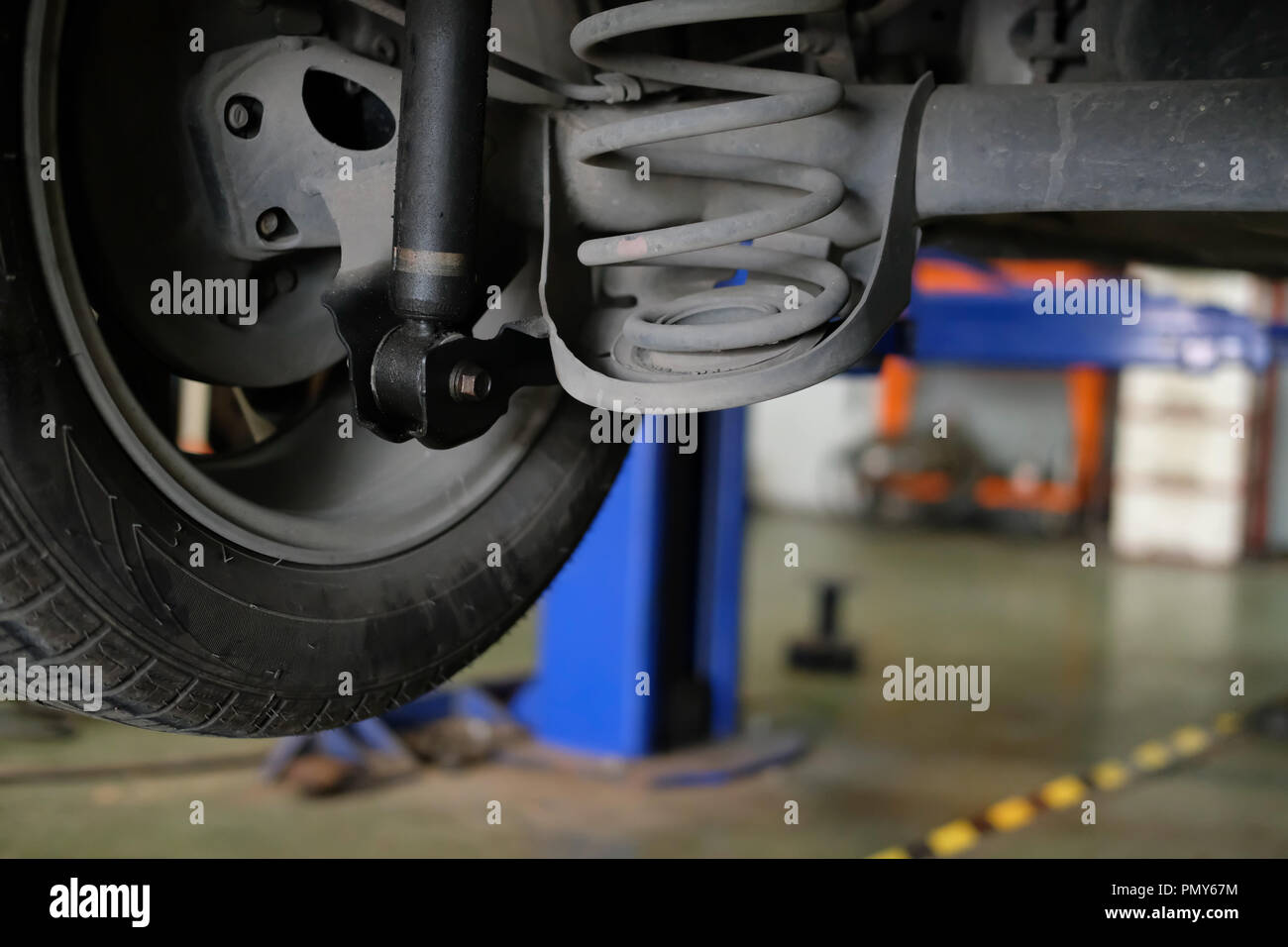 damaged rear car shock absorber & spring in auto service repair garage