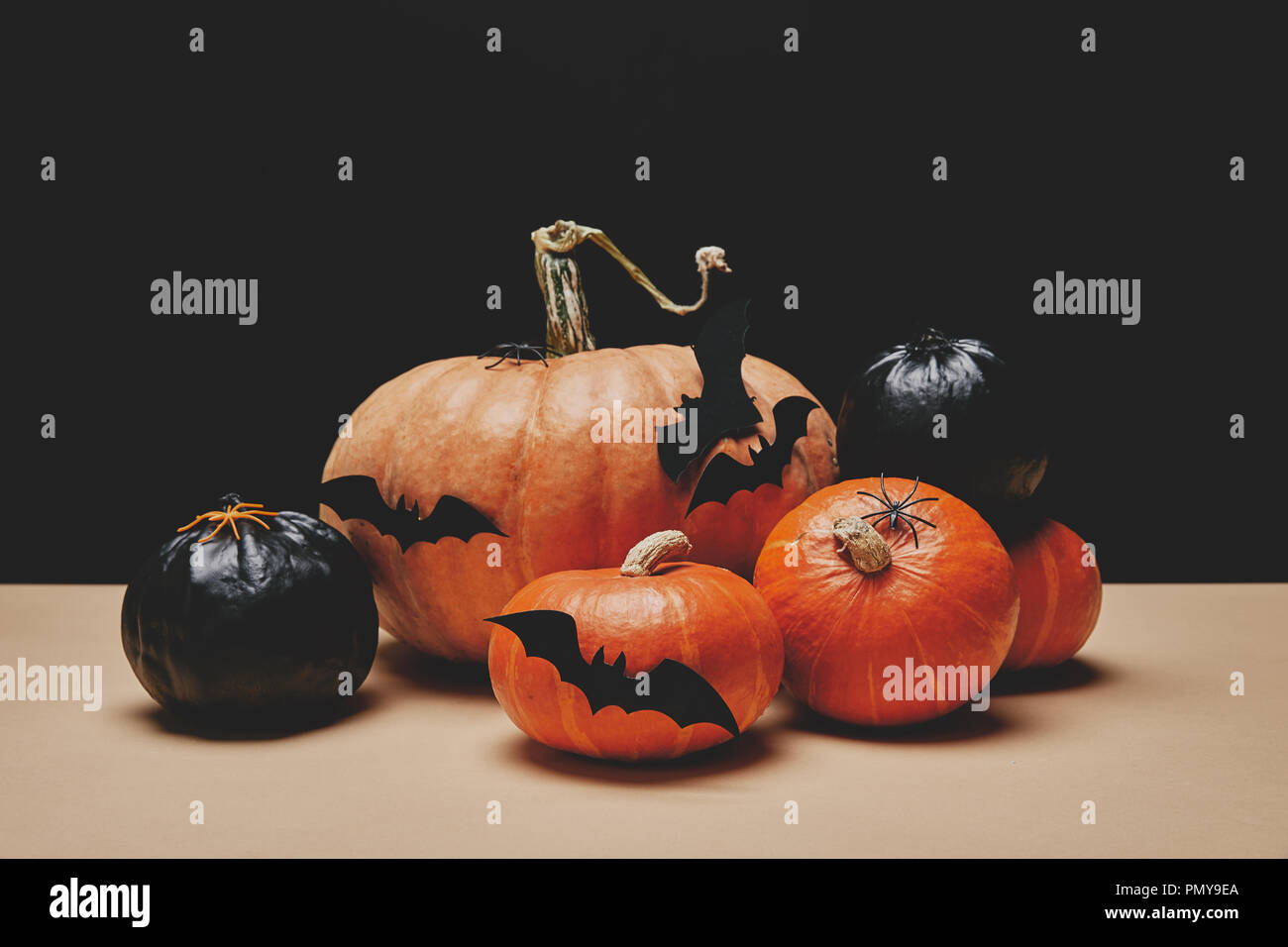 orange and black pumpkins with paper bats on table, halloween concept ...