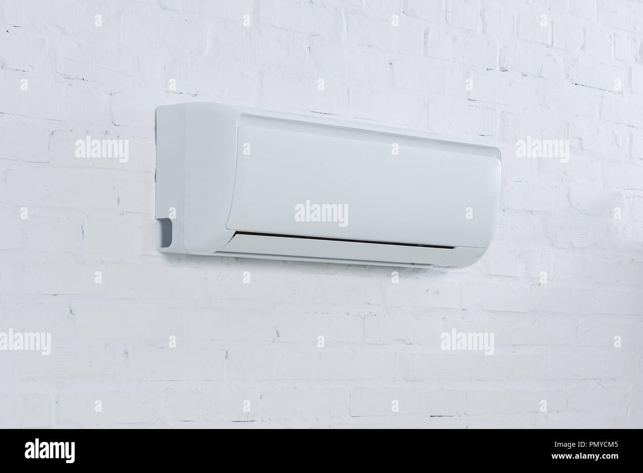 close-up shot of air conditioner hanging on brick wall Stock Photo - Alamy