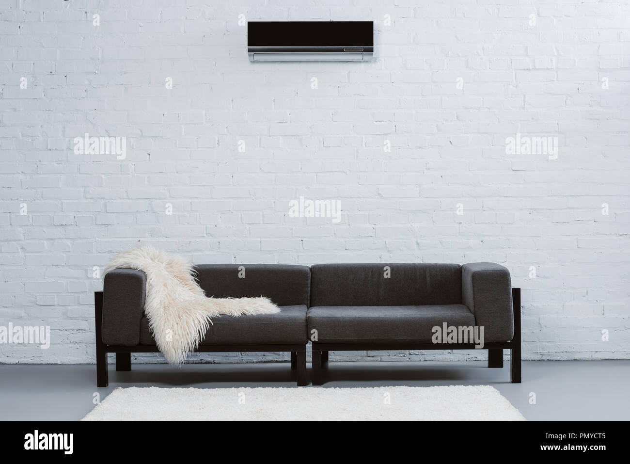 air conditioner hanging on white brick wall at living room Stock Photo ...