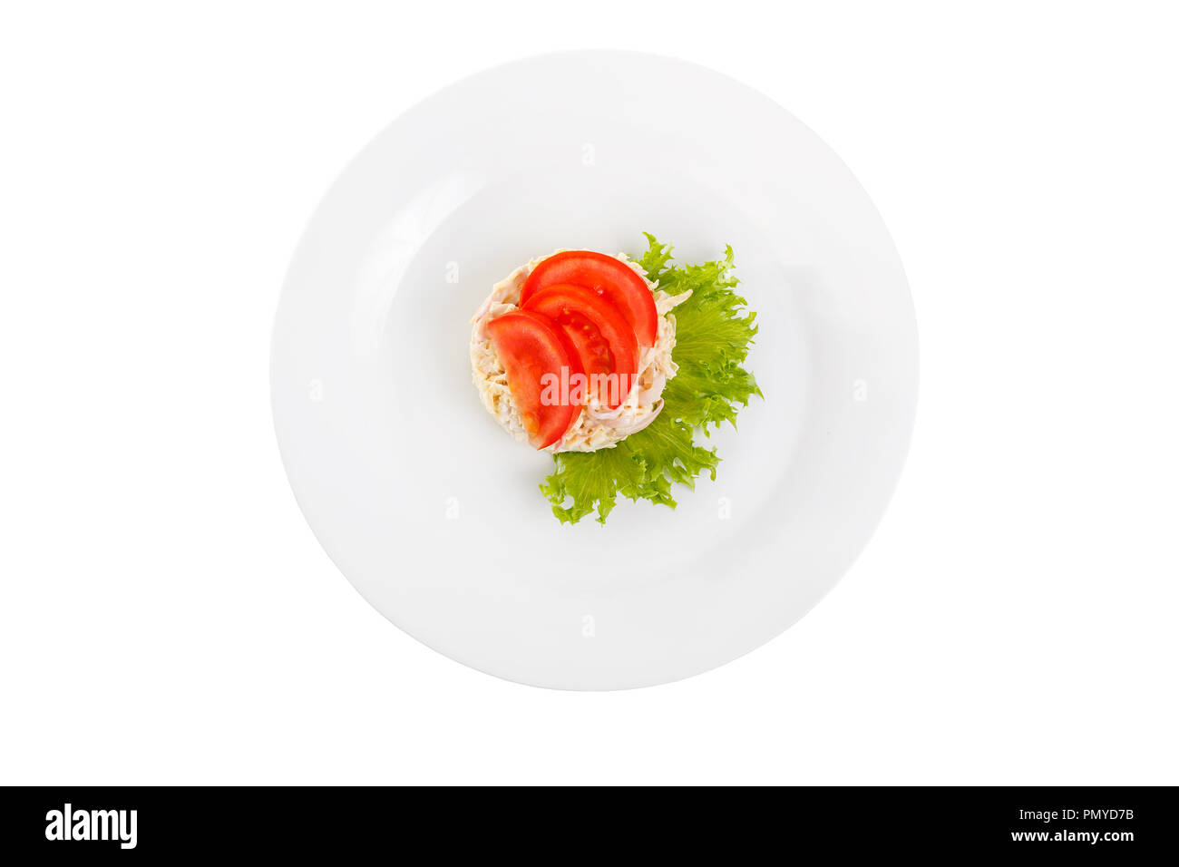 Salad with seafood from squid, eggs, potatoes, cheese, bacon, decorated with tomato slices and lettuce leaf on plate, white isolated background, view  Stock Photo