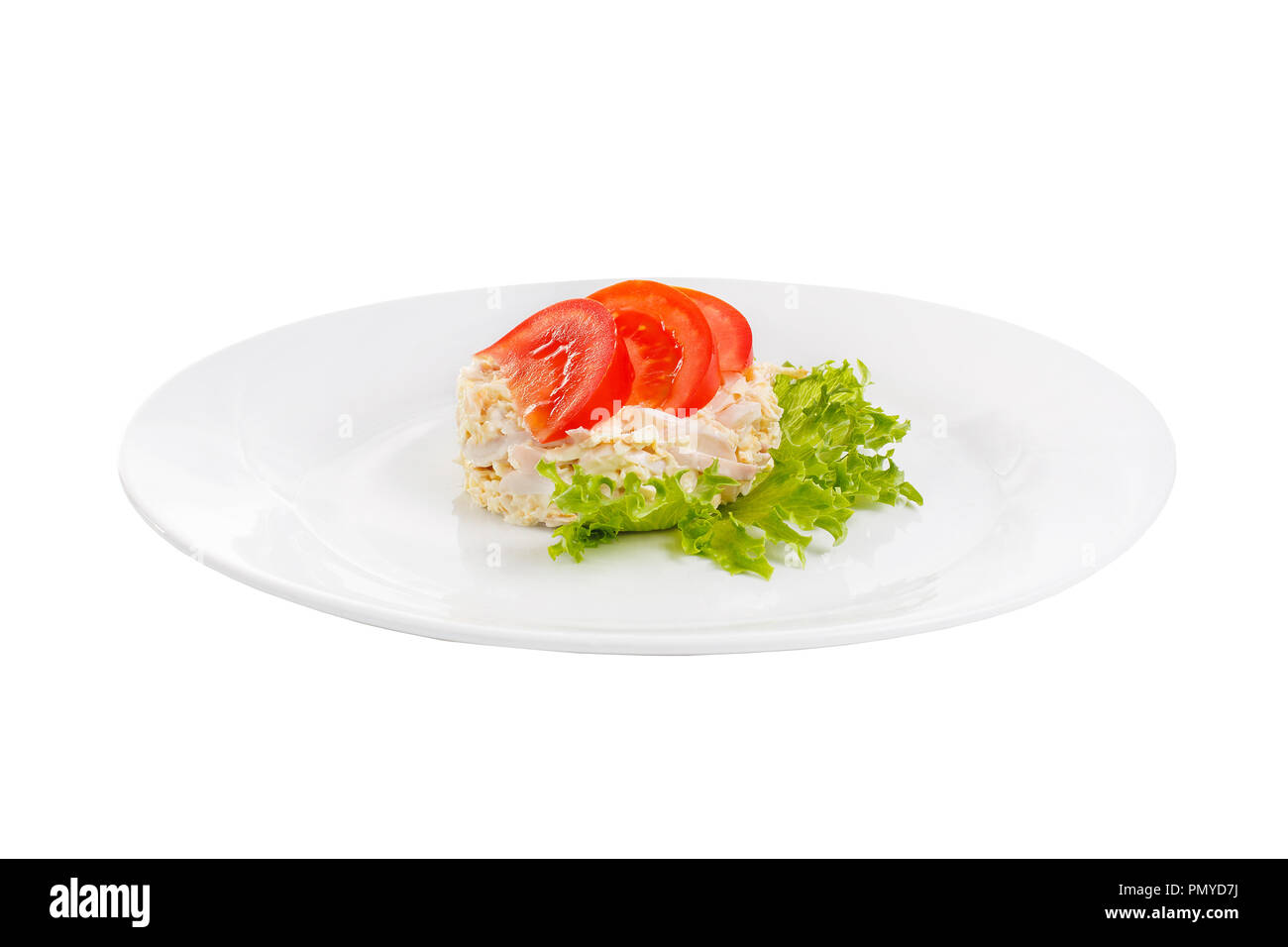 Salad with seafood from squid, eggs, potatoes, cheese, bacon, decorated with tomato slices and lettuce leaf on plate, white isolated background Side v Stock Photo
