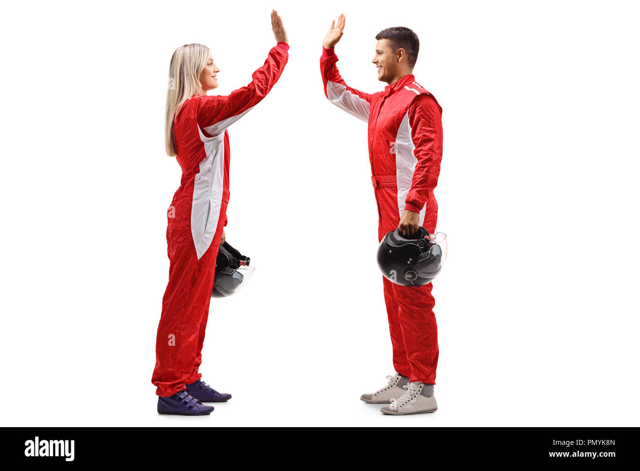 Full length profile shot of a female and a male racer high-fiving each other isolated on white background Stock Photo