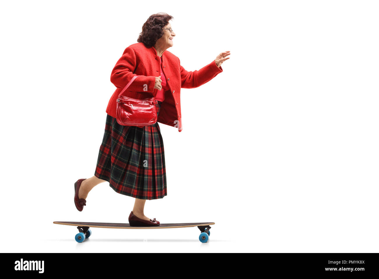 Full length profile shot of an elderly lady riding a longboard isolated on white background Stock Photo