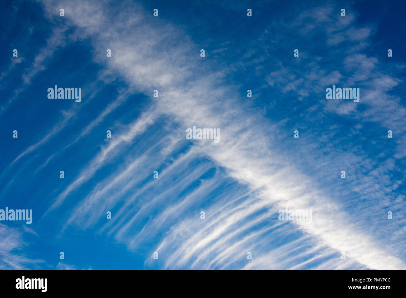 Wispy Cirrus cloud formations against a deep blue sky. Stock Photo