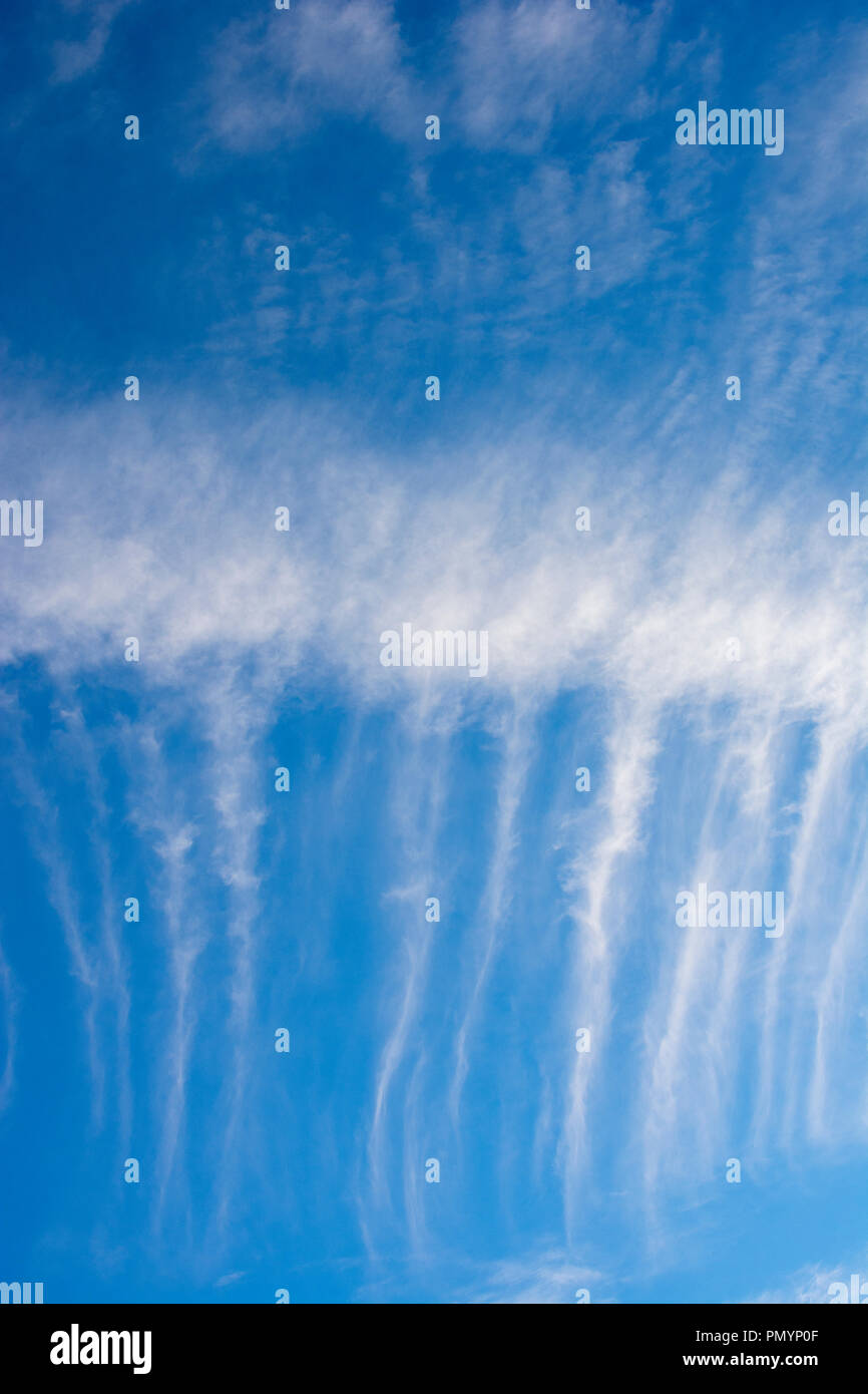 Wispy Cirrus cloud formations against a deep blue sky. Stock Photo