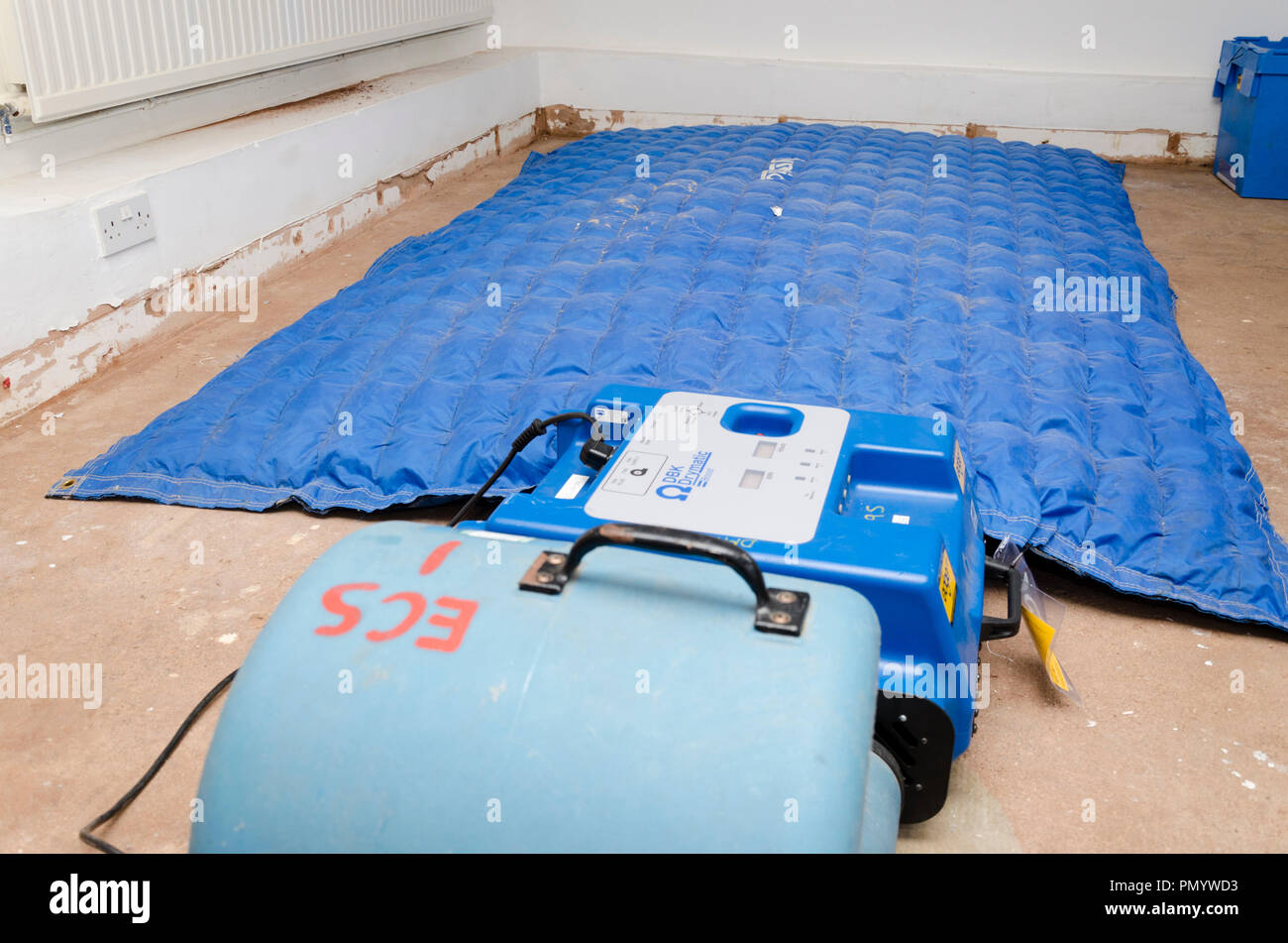 Drying out damp room after flood damage to concrete floor with Direct Air Dryer mat. Stock Photo
