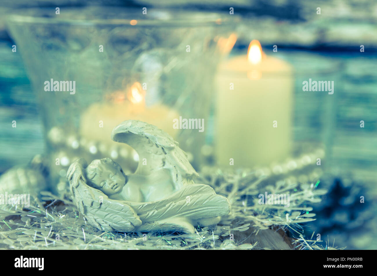 sleeping angel figure and two festive burning candles Stock Photo Alamy