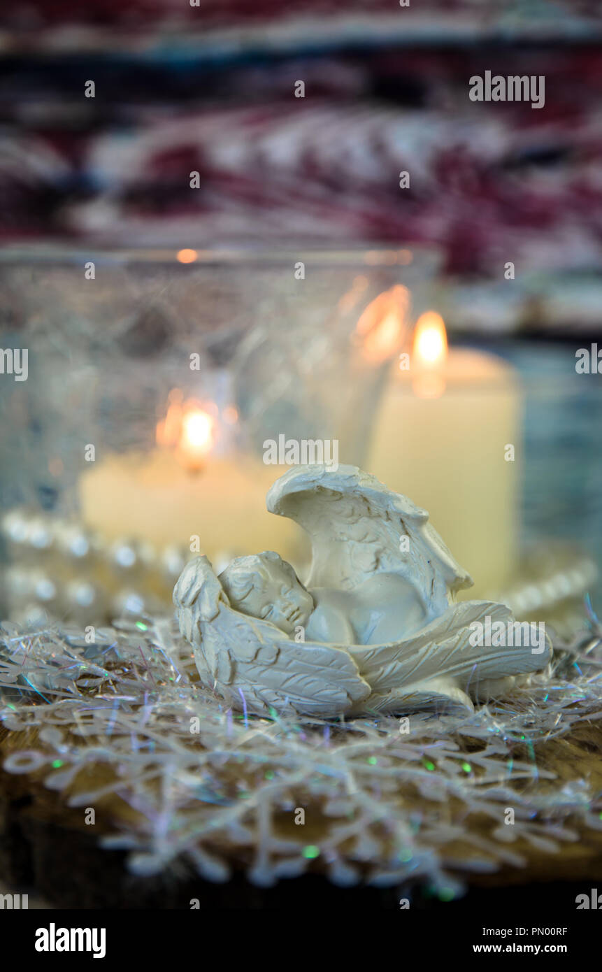 sleeping angel figure and two festive burning candles Stock Photo Alamy