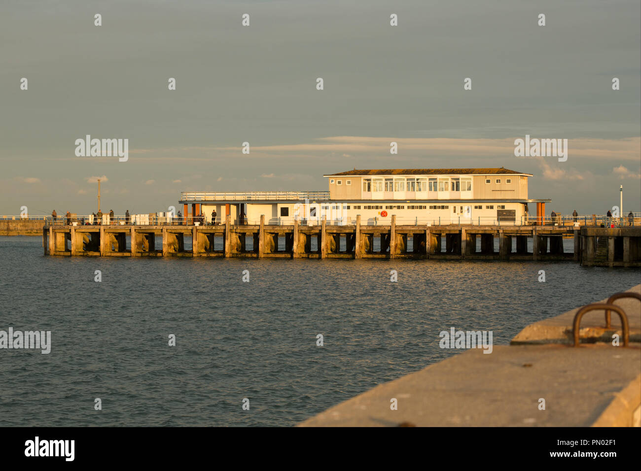 Evening light on the Weymouth Pleasure Pier with anglers fishing. The