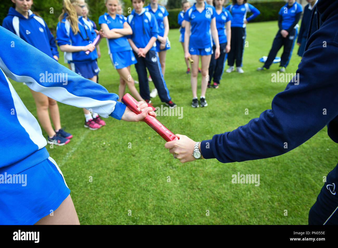 Students practice baton relay during a Physical Education (PE) lesson on the school playing