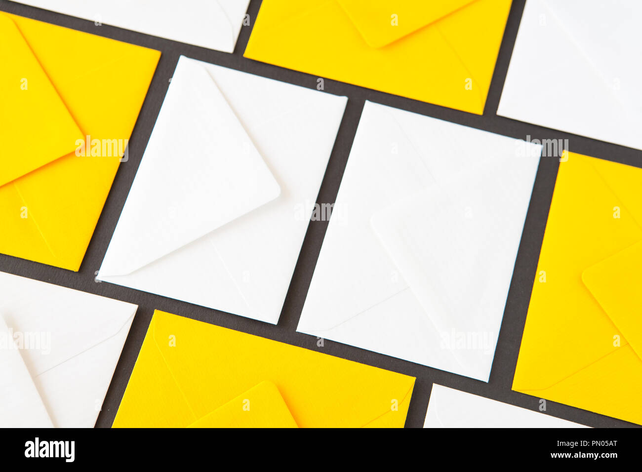 Composition with white and yellow, envelopes on the table. Different colored envelopes on the table. Stock Photo