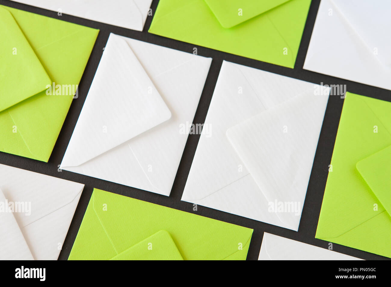 Composition with white and green envelopes on the table. Different colored envelopes on the table. Stock Photo