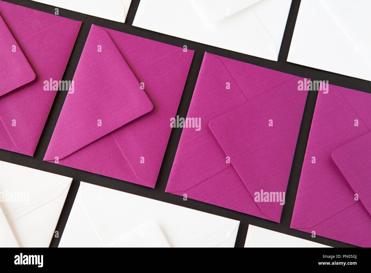Composition with white and purple envelopes on the table. Different colored envelopes on the table. Stock Photo