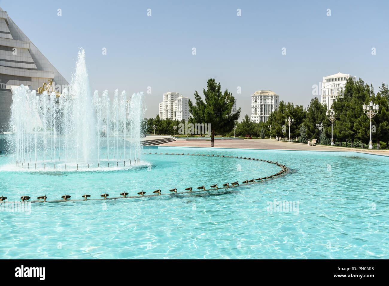 typical white marble-clad building surrounded by fountains in the Independance Park in Ashgabat, Turkmenistan Stock Photo