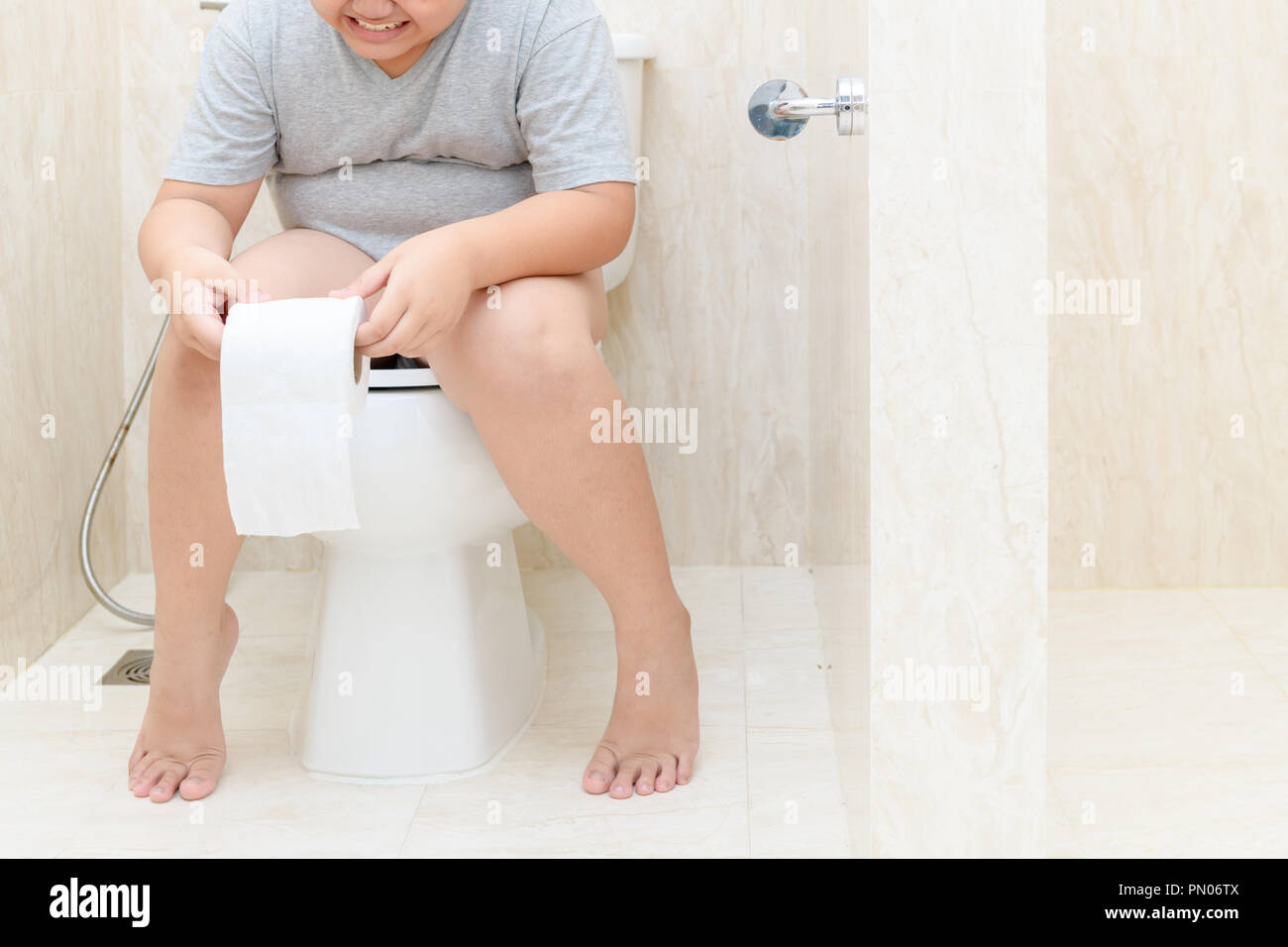 Child sitting in toilet and holding tissue roll, diarrhea constipation