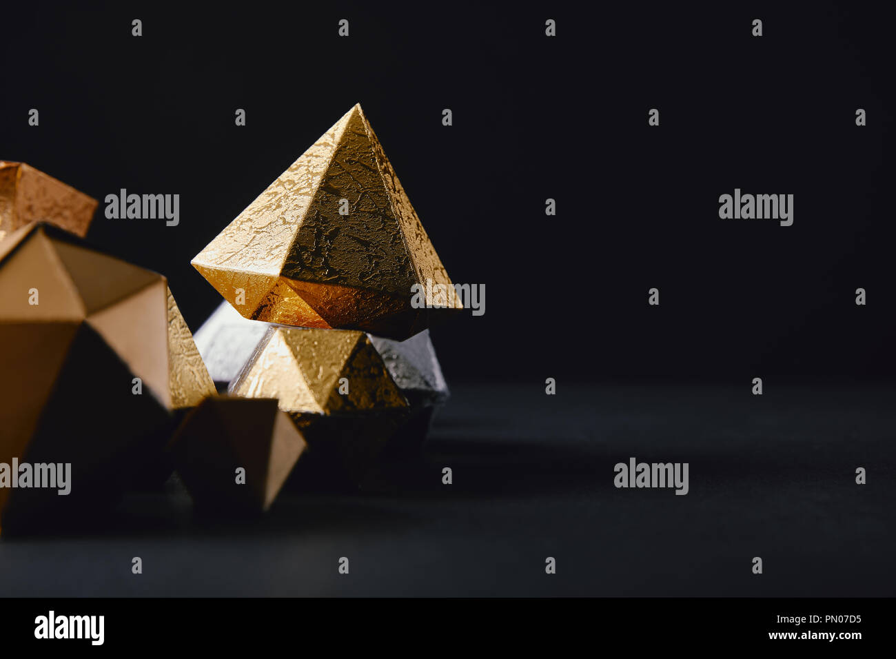 cose-up view of shiny faceted glittering gold pieces on black background Stock Photo