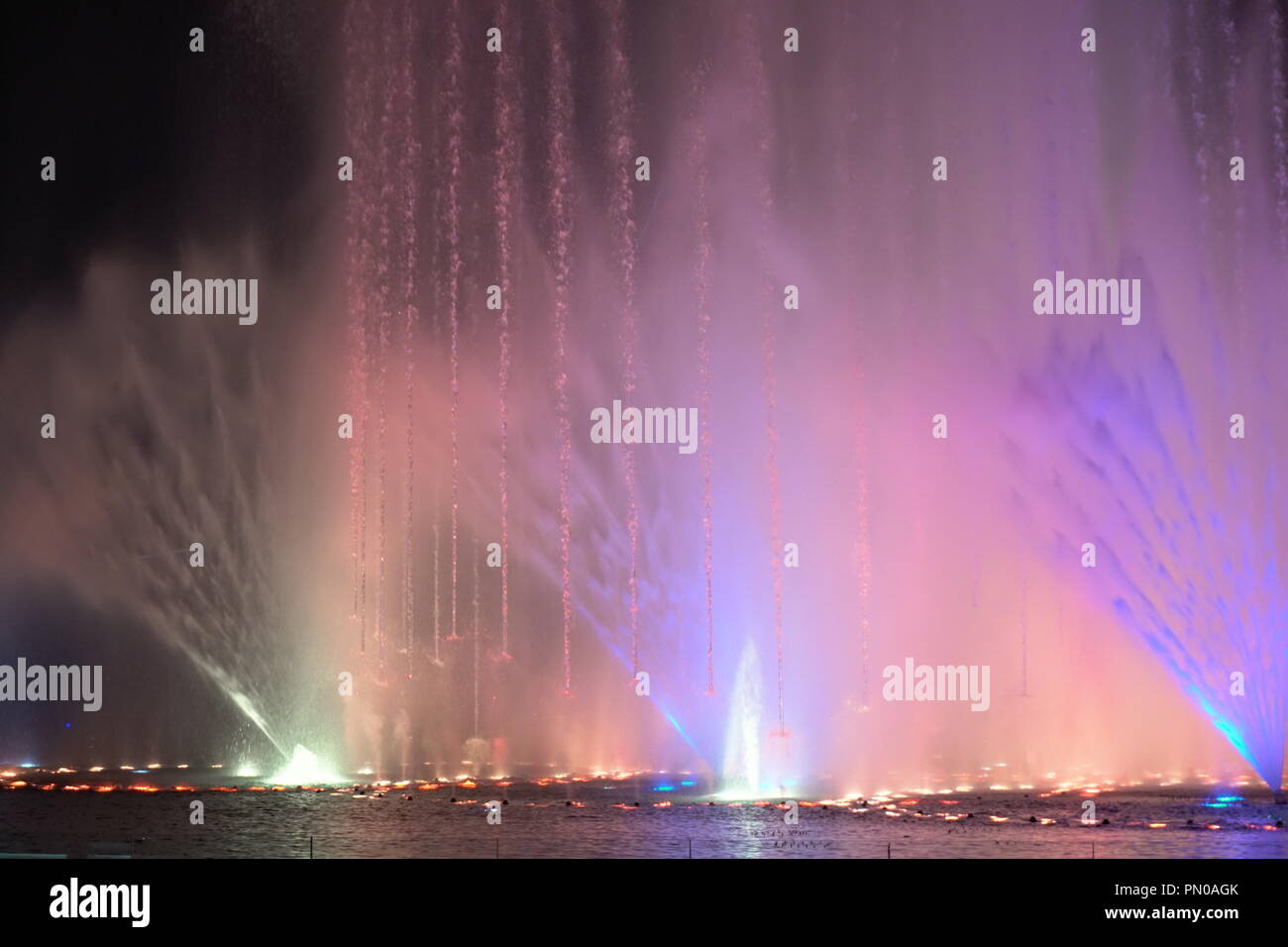 multi-coloured jets of water fountain illuminated lights Stock Photo