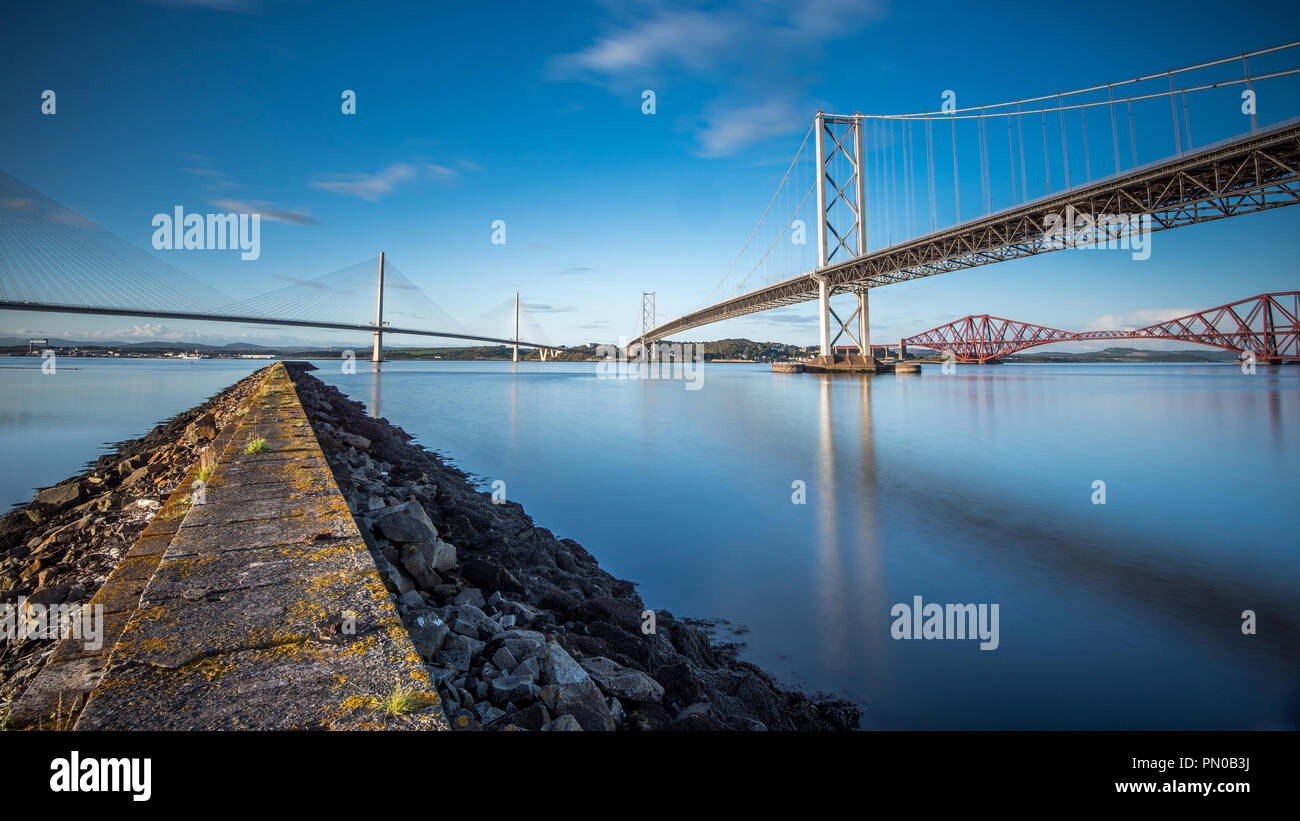 The three Forth Bridges are an impressive sight as they across the Firth of Forth, as well as providing road and rail transport links into Edinburgh Stock Photo