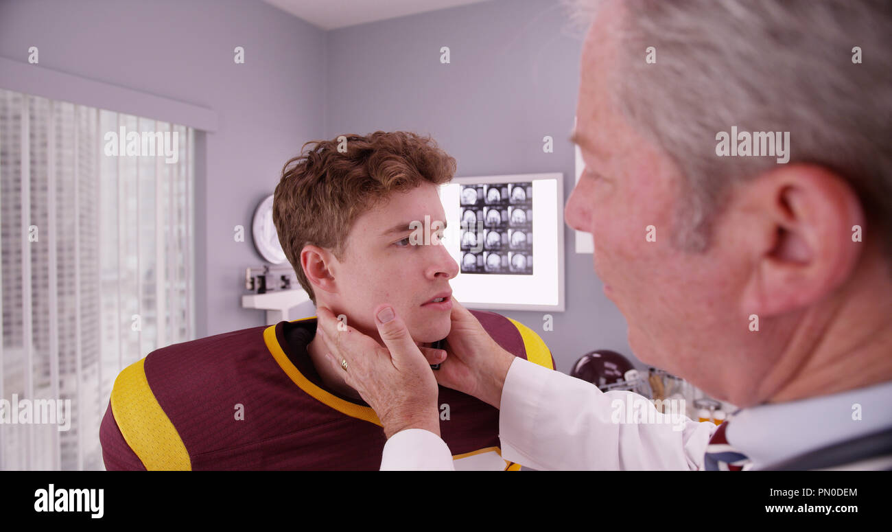 Senior sports medicine doctor examining athlete's neck