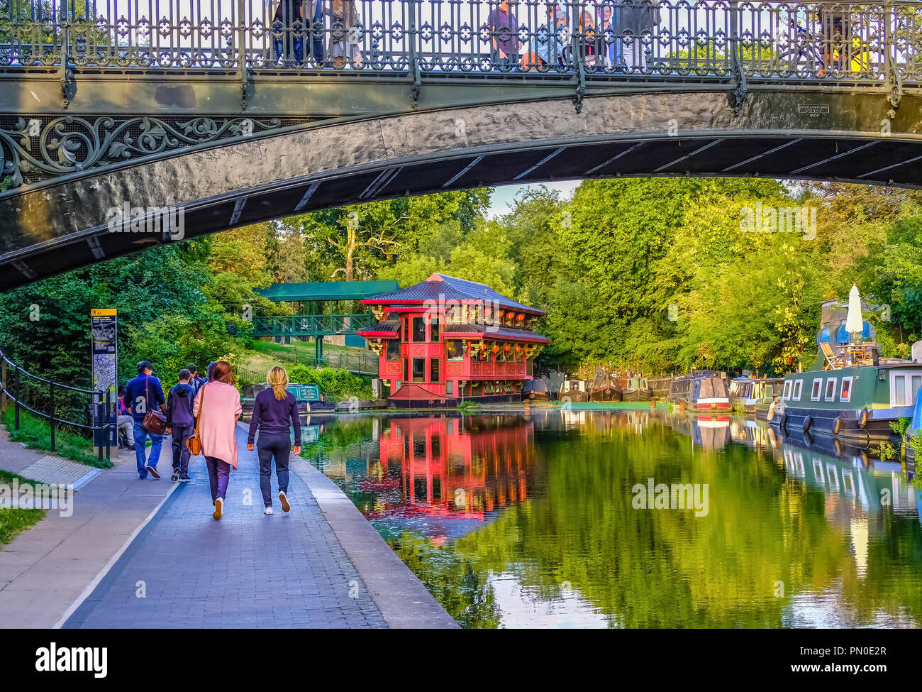 Beautiful view of Regent's Canal in London, England, at sunset in the summer; people walking along, bridge above Stock Photo