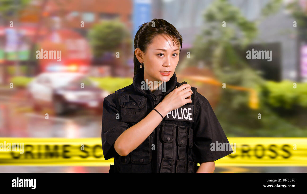 Asian American Woman Police Officer at Crime scene Calling for Backup on CB  Radio Stock Photo - Alamy