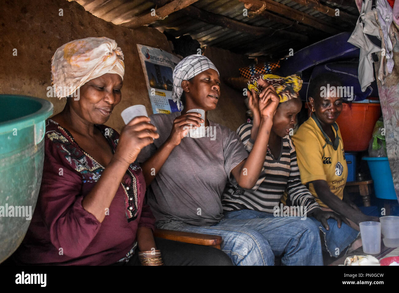 Women seen taking alcohol. Women from Kibera slums at the age of twenty-five and above are selling alcohol to survive through their daily life. As many women might take alcohol as a way of celebration and as a way of connecting with friends and family during their fun moments, In one of Nairobi largest slum Kibera, women here consume it for different reasons including taking over stress and forgetting about their family problems back home. Stock Photo