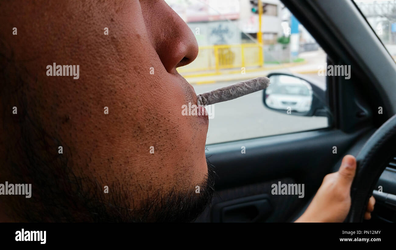 Man smoking marijuana cigarette soft drug in Lima - Peru Stock Photo