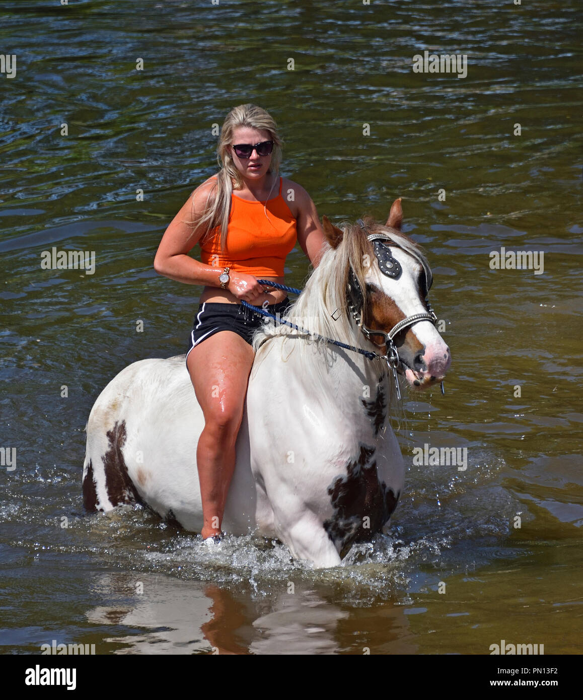 Gypsy Traveller girl riding horse in River Eden. Appleby Horse Fair 2018. Appleby-in-Westmorland, Cumbria, England, United Kingdom, Europe. Stock Photo