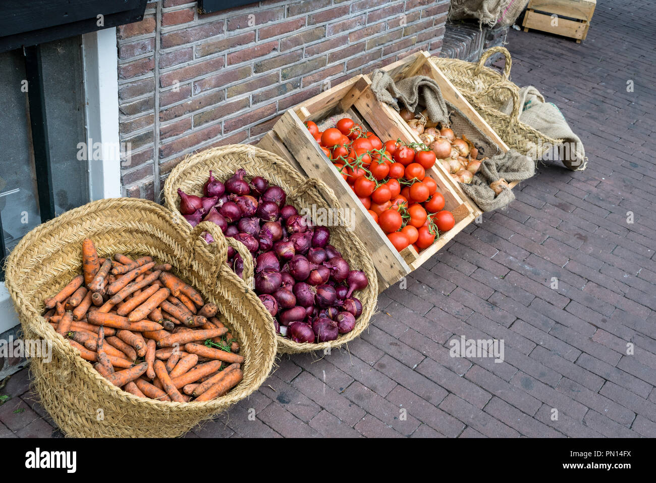This is baskets and crates of fresh vegetables in an outside market ...
