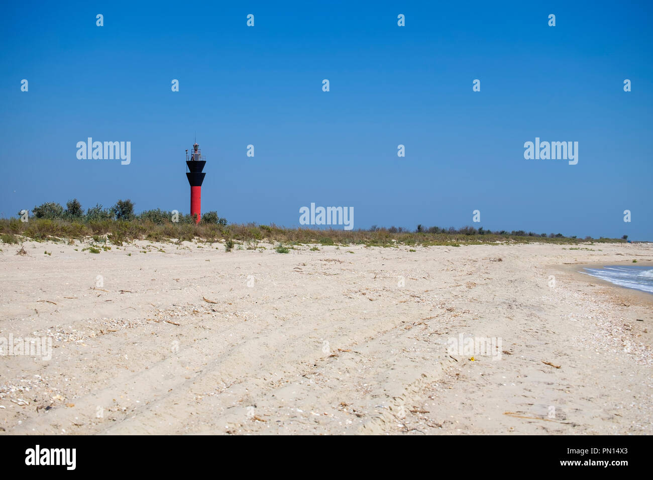 Sandy beach and 16-meter lighthouse Shagany in the distance (Ukraine, Rasseika, Tuzlovski Lagoons National Park) Stock Photo
