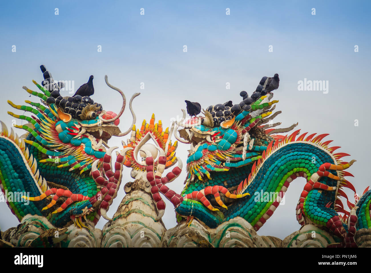 Beautiful two large grimace dragons crawling on decorative tiles roof ...