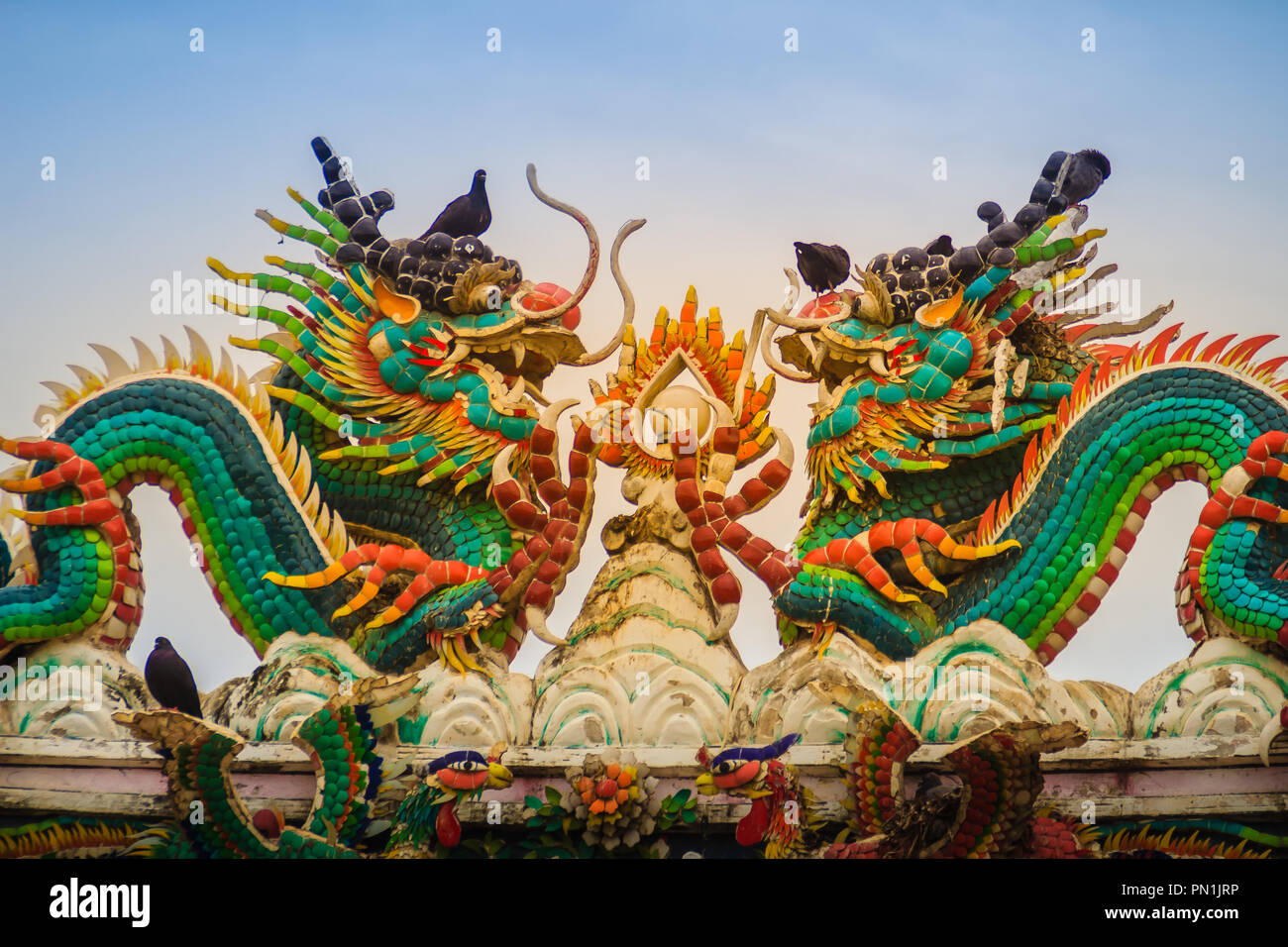 Beautiful two large grimace dragons crawling on decorative tiles roof ...
