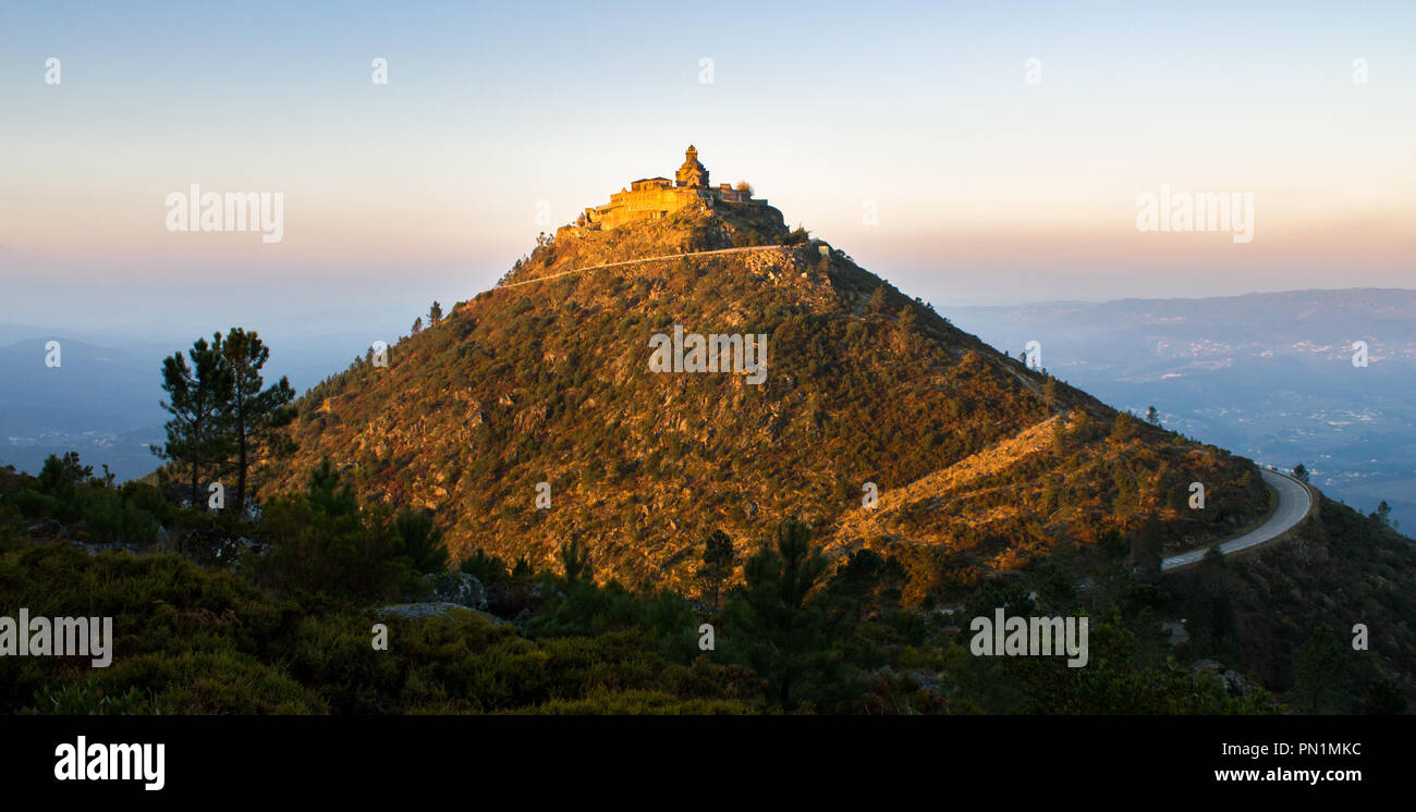 A sanctuary is lit by the sun reflection during sunrise, on top of a hill. Stock Photo