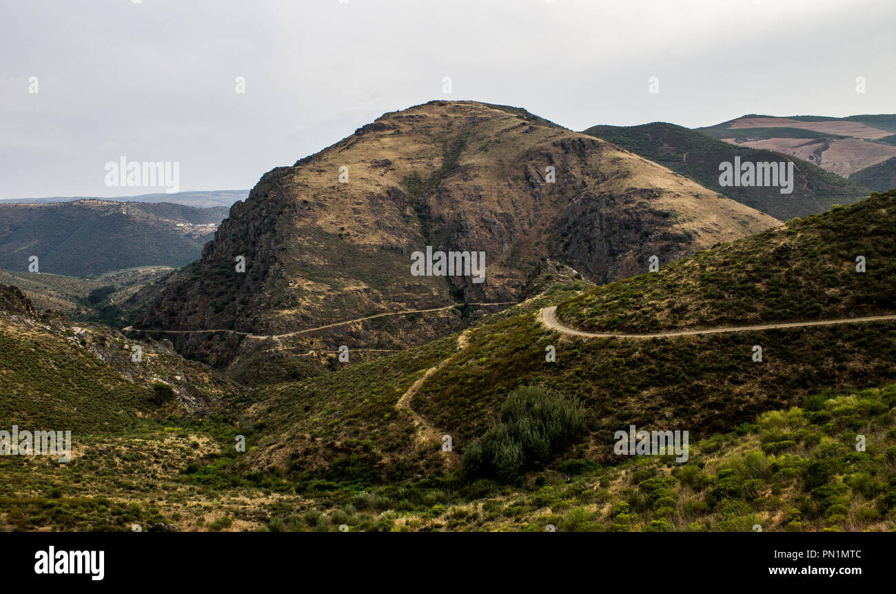 Various paths converge on a mountain top on an overcast day. Stock Photo