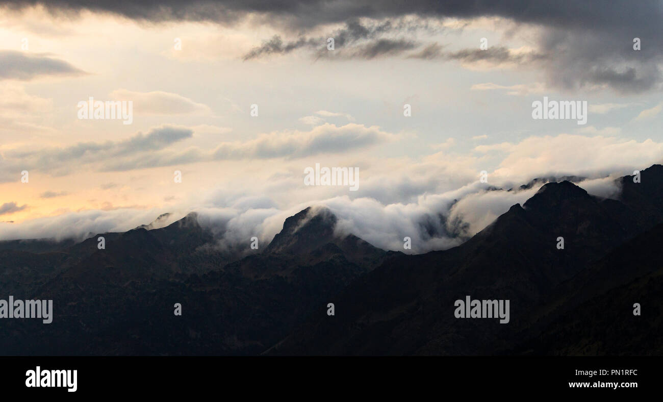 A panoramic view of the clouds and mist surrounding the mountain range. Stock Photo