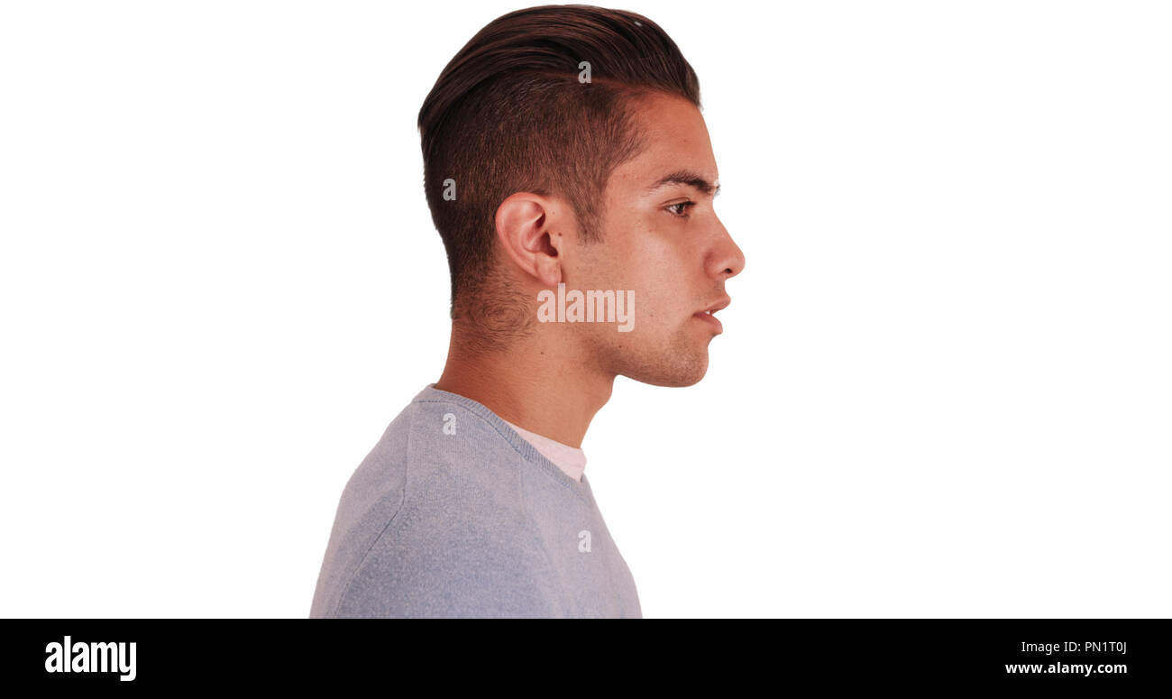 Side view of Hispanic man with cool undercut standing with white background Stock Photo