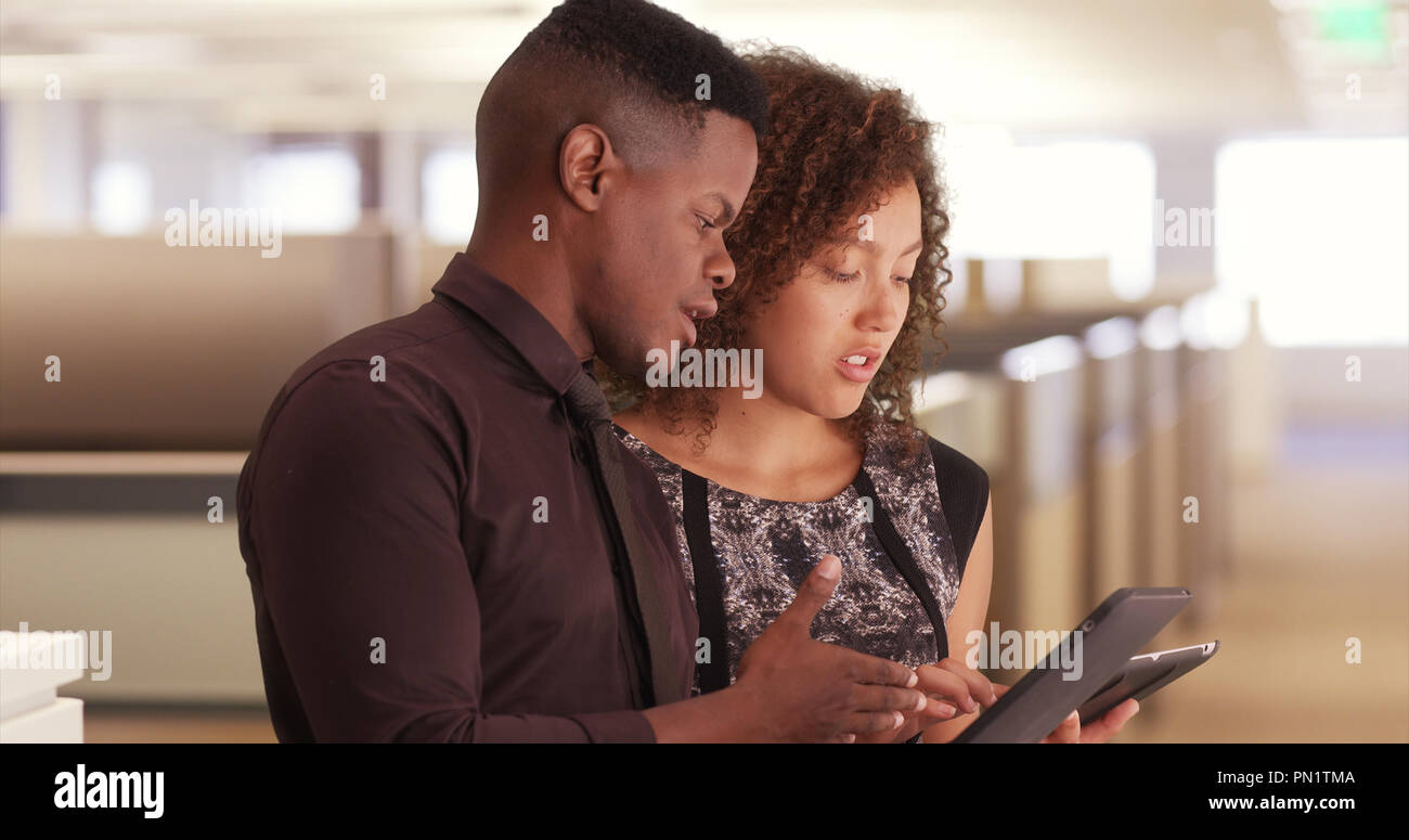 Two black office workers using pads in a modern workplace Stock Photo ...