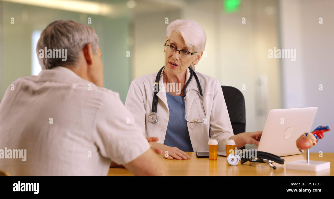 Experienced doctor talking with elderly man in the office Stock Photo