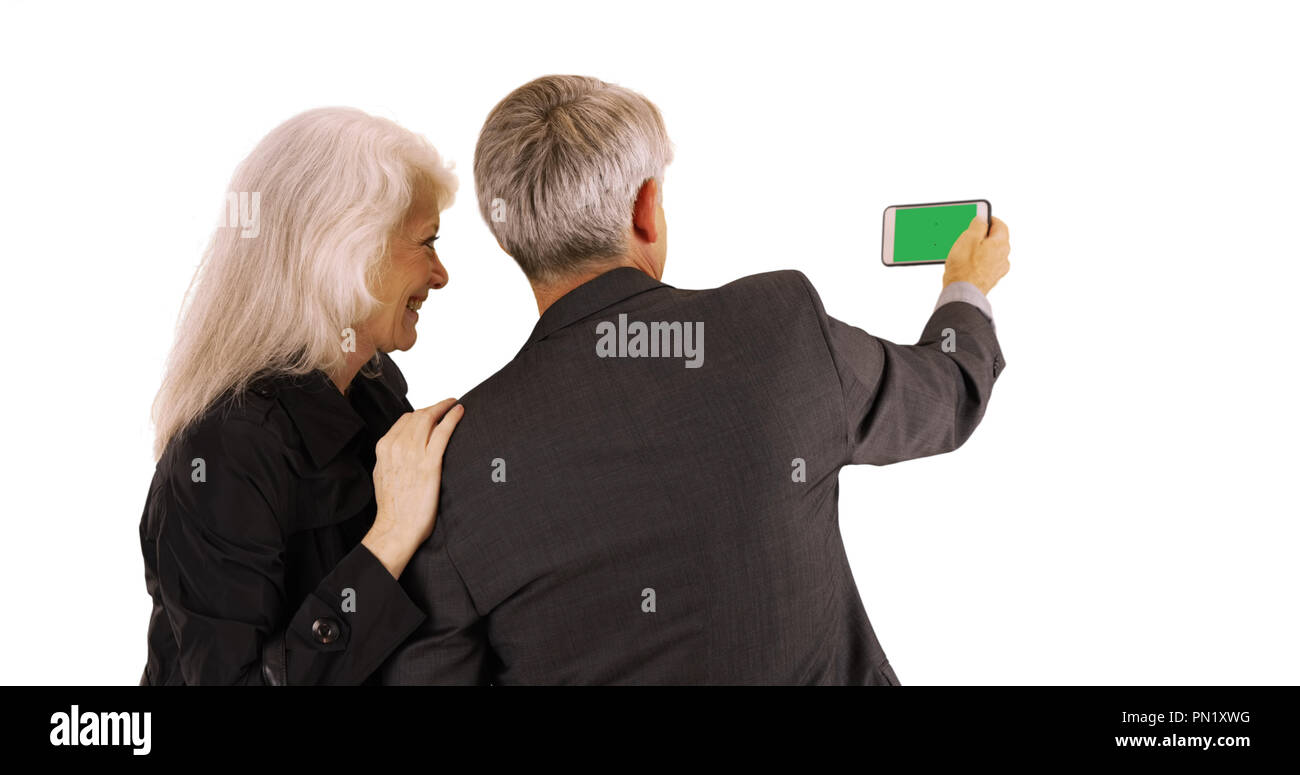 Senior couple using smartphone with green screen on white background Stock Photo