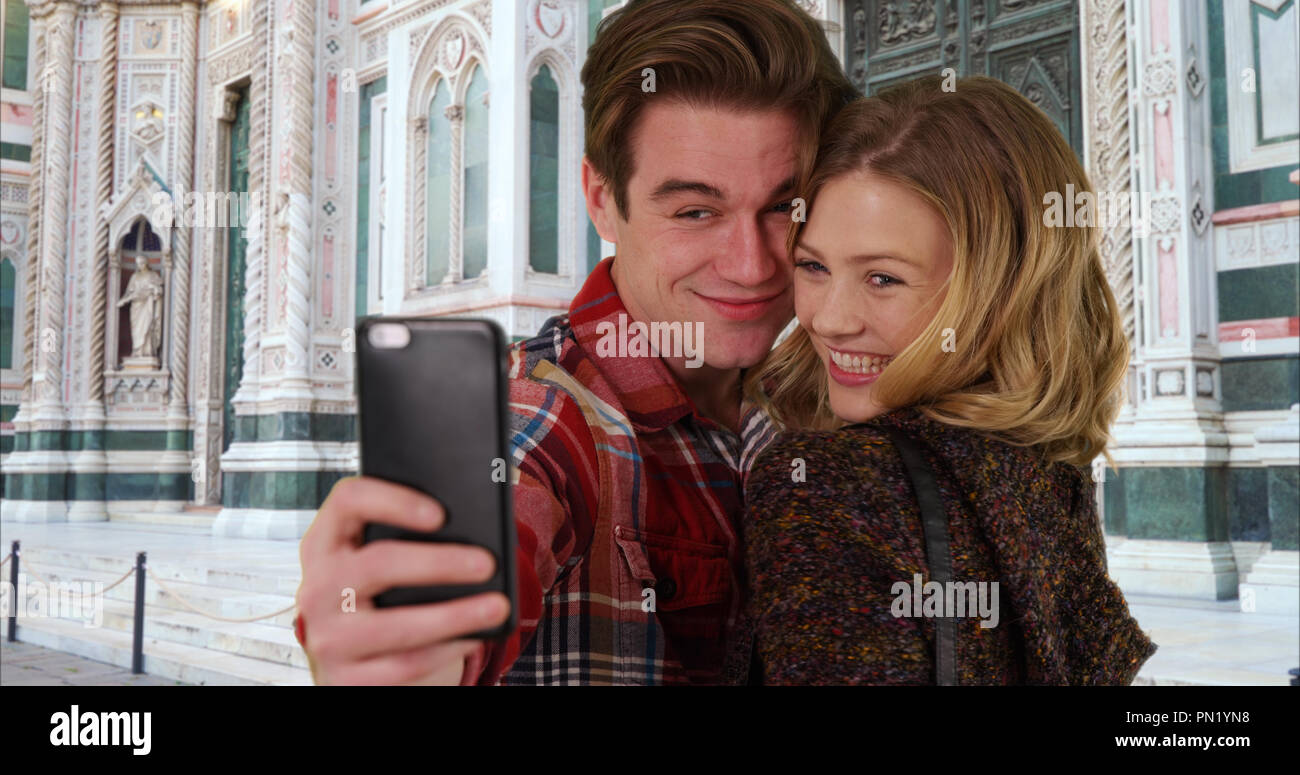 Cheerful young taking a selfie in front of Florence Cathedral smiling ...