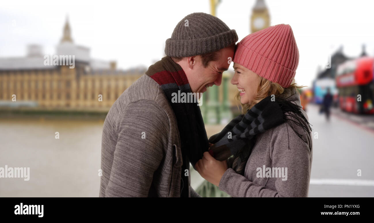Happy Caucasian couple on Westminster Bridge looking into each others eyes Stock Photo